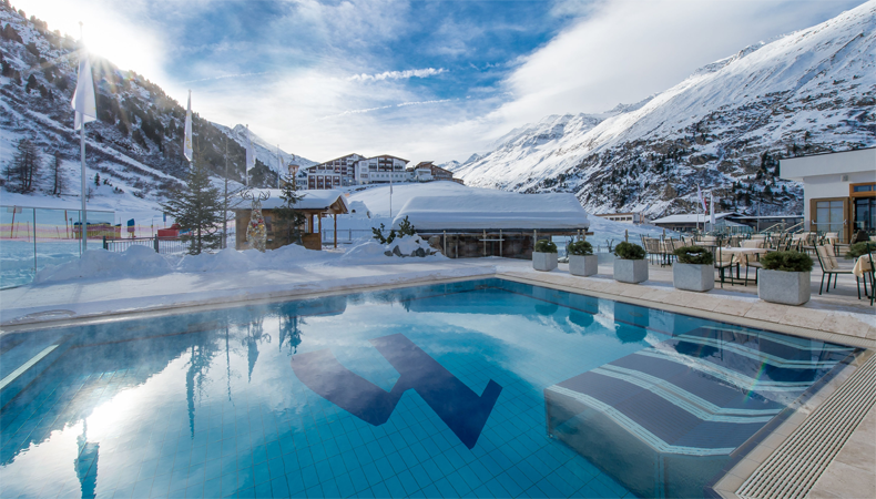 Vanuit het binnenzwembad zwem je zo naar buiten en geniet je van het prachtige berglandschap van Obergurgl. © Alpen-Wellness Resort Hochfirst