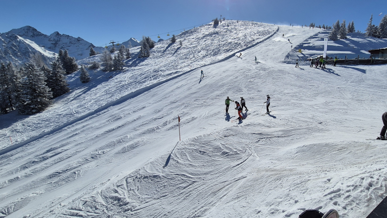 Piste 9, de rode Burgstallalmabfahrt loopt langs het bergstation van de Planai-gondel. © Nico van Dijk / Skigebiedengids.nl