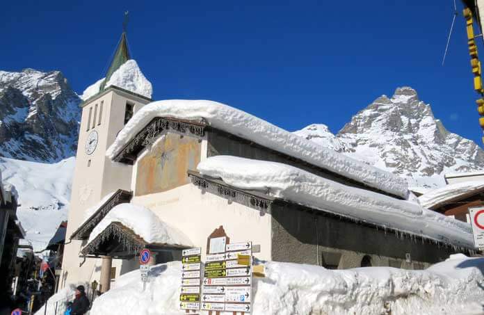 Wintersport in Cervinia: de kerk met op de achtergrond de Cervino © SkigebiedenGids.nl